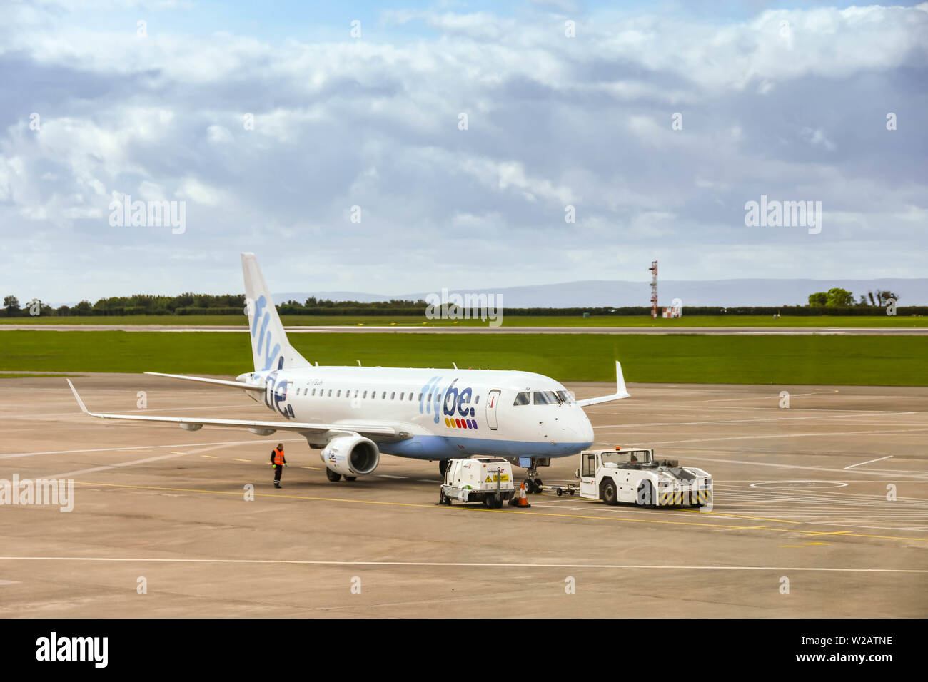 CARDIFF WALES FLUGHAFEN - JUNI 2019: Flybe Embraer E175 Flugzeug einen Flughafen Schlepper für Abfahrt von Cardiff Wales Flughafen geschoben werden. Stockfoto