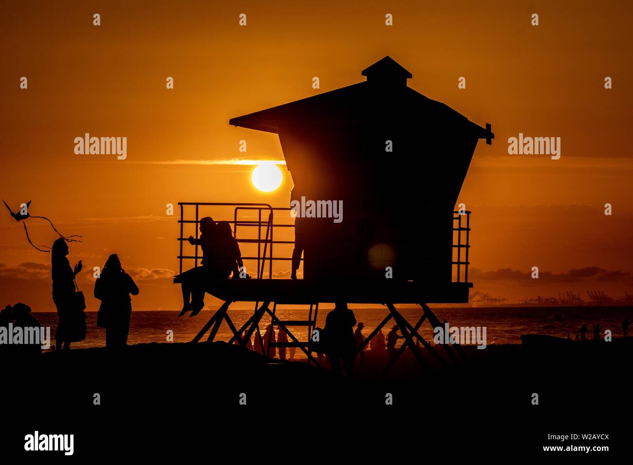 Silhouetten von Menschen am Strand bei Sonnenuntergang Stockfoto