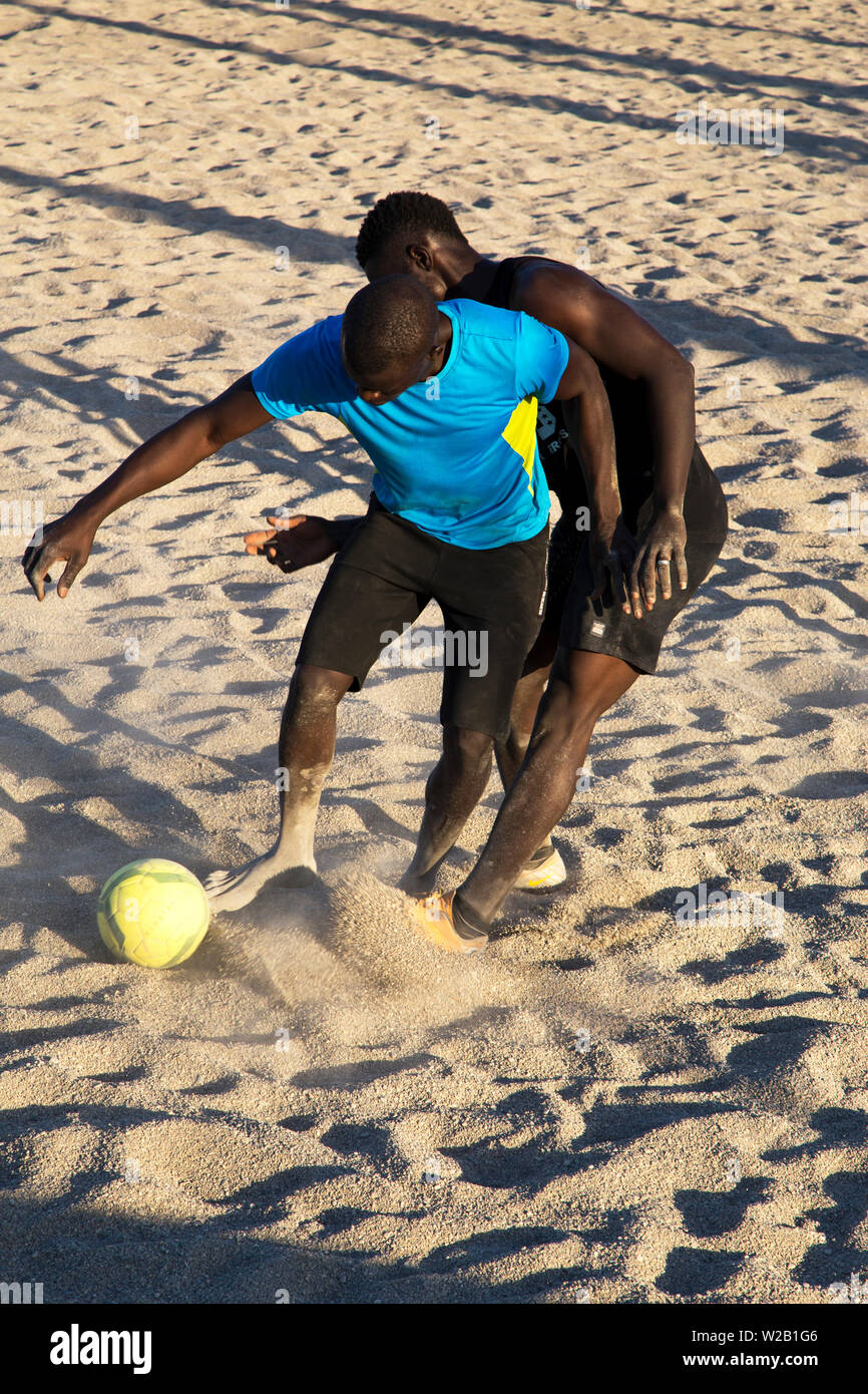 Die afrikanischen Männer Fußball spielen am Strand Stockfoto