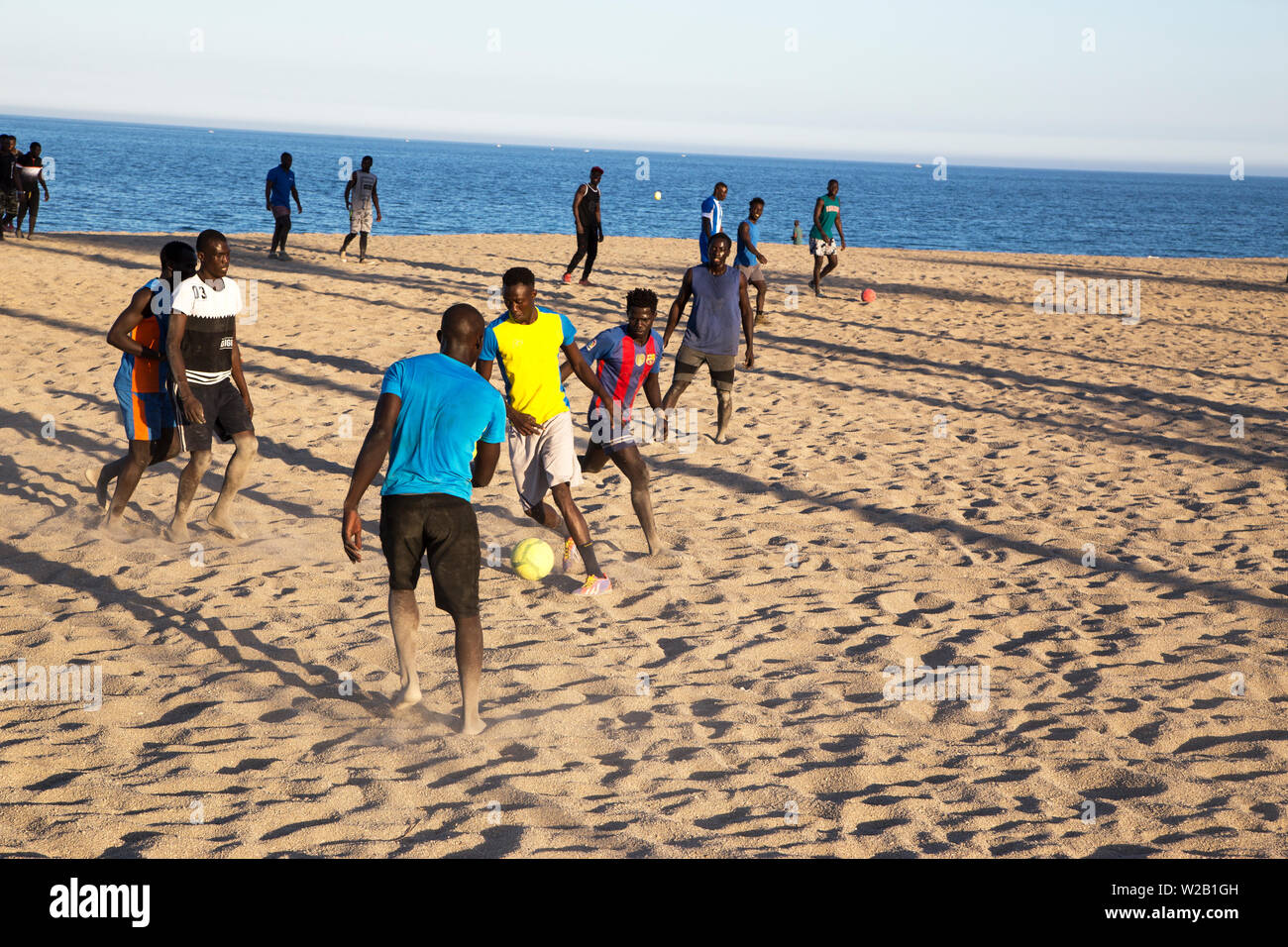 Die afrikanischen Männer am Strand Fußball spielen Stockfoto
