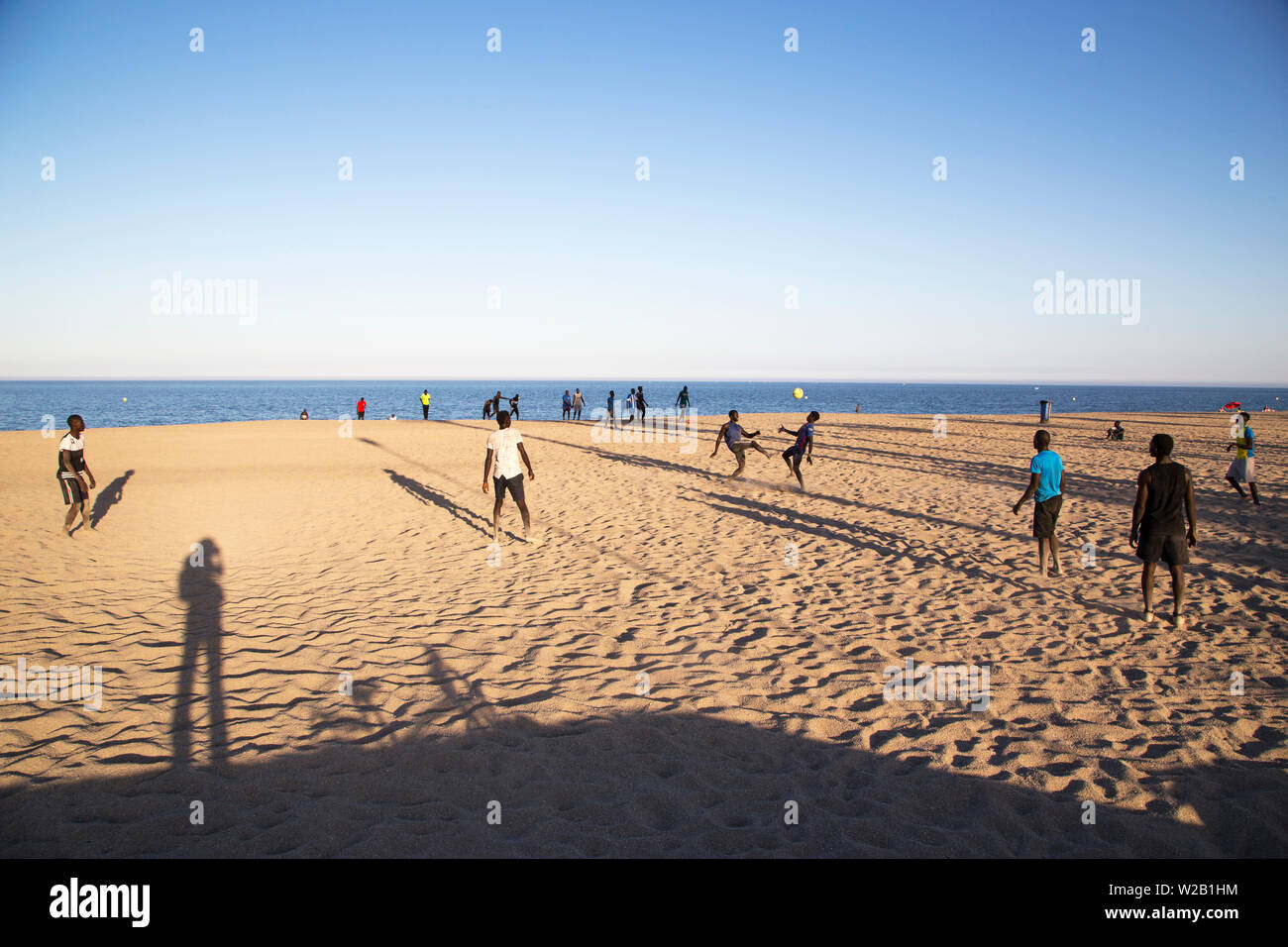 Die afrikanischen Männer am Strand Fußball spielen Stockfoto