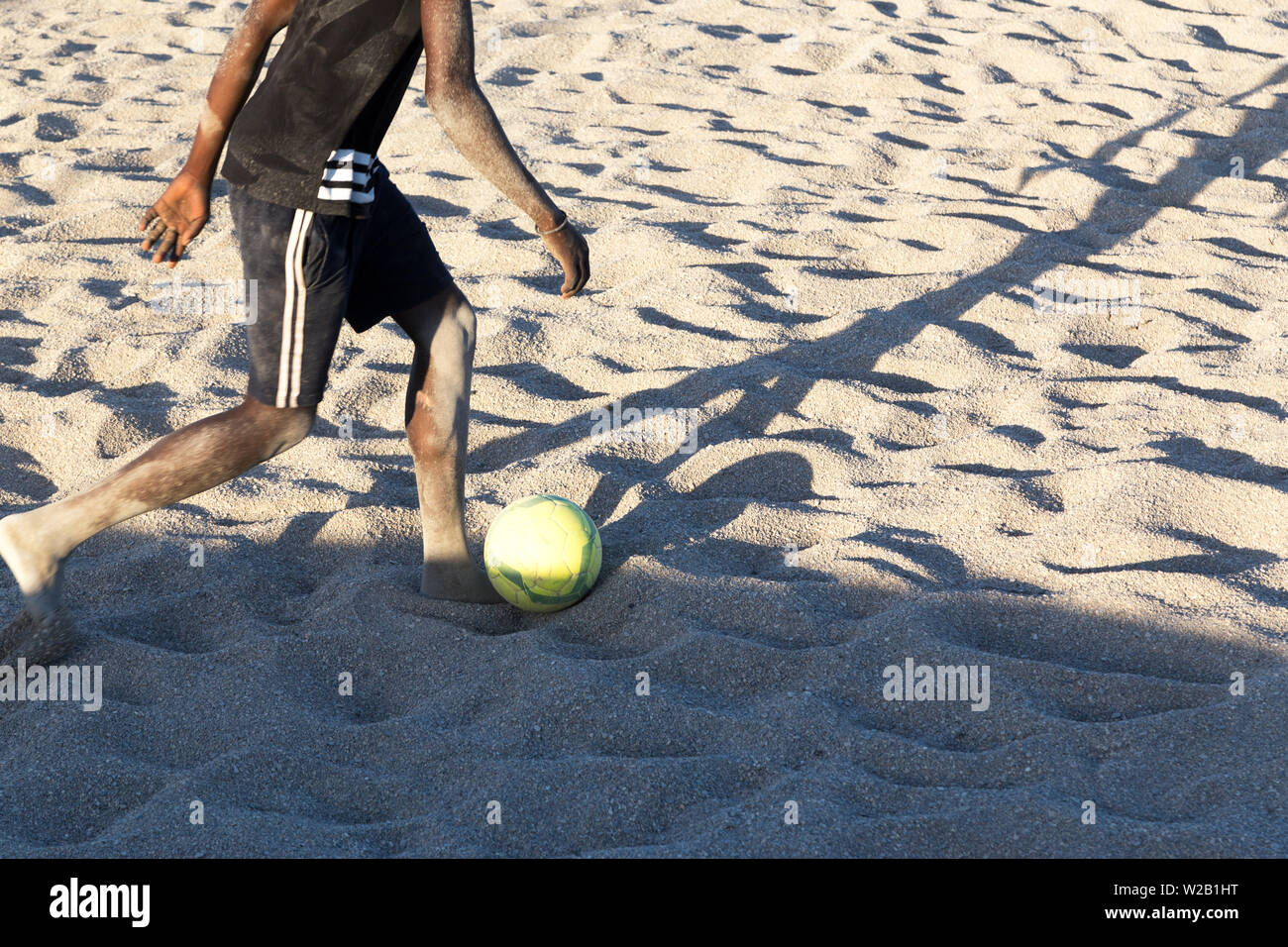 Die afrikanischen Männer am Strand Fußball spielen Stockfoto