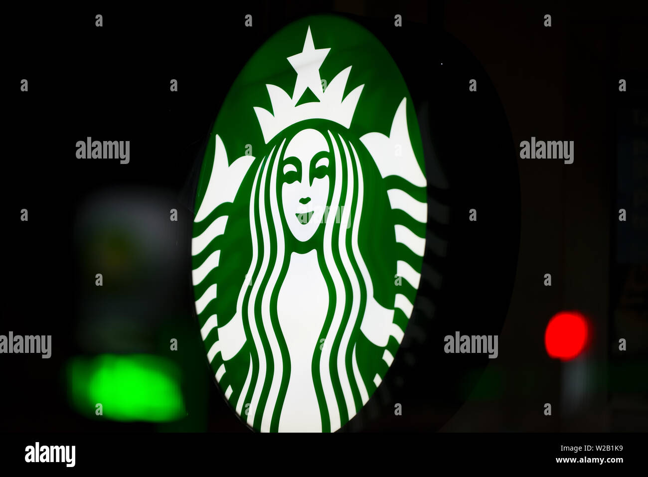 MINNEAPOLIS, Minnesota/USA - Juli 3, 2019: Starbucks Zeichen auf ein Minneapolis Sommernacht mit Straßenbeleuchtung auf Fenster beleuchtet Stockfoto