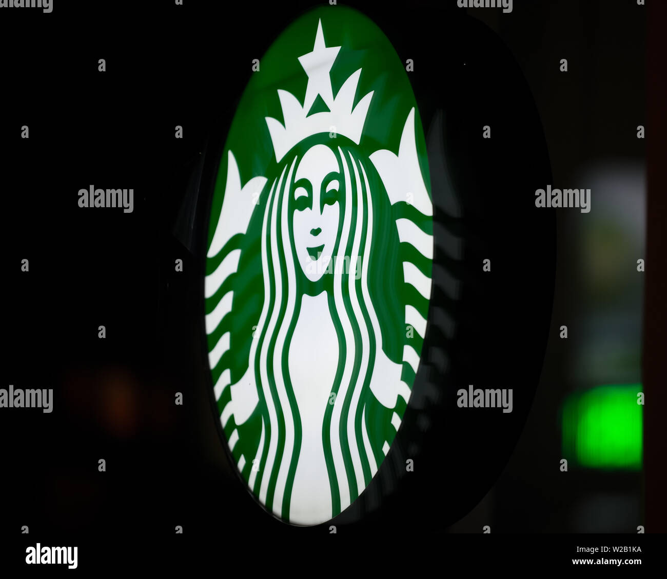 MINNEAPOLIS, Minnesota/USA - Juli 3, 2019: Starbucks Zeichen auf ein Minneapolis Sommernacht mit Straßenbeleuchtung auf Fenster beleuchtet Stockfoto