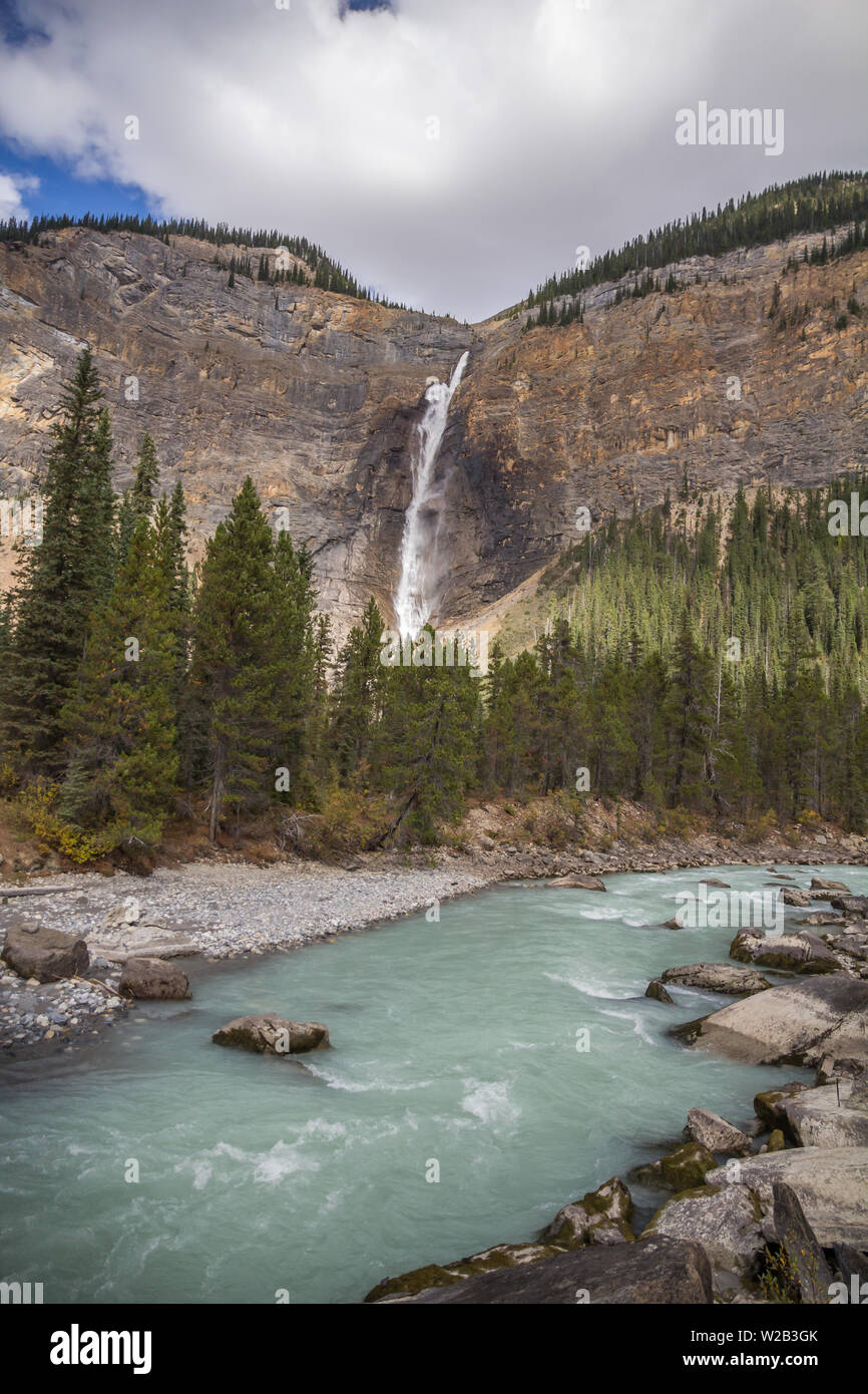 Sunlit Wasser purzelt unten Takakkaw Falls im Yoho National Park, BC, Kanada. Ein schnell fließenden Bach - türkis mit glazialen Schlick - im Vordergrund. Stockfoto