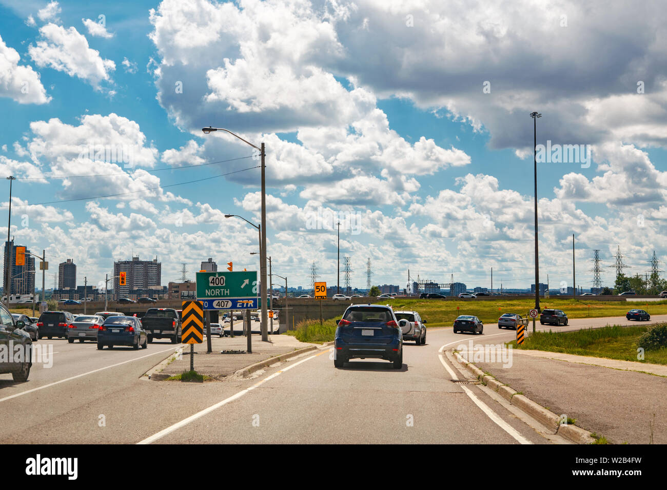 Schöne Landschaft 12:00 Uhr Ausblick auf Toronto City Autobahn Straße mit Autos Verkehr während der sonnigen Tag mit weißen Wolken im blauen Himmel. Besetzt outdoor Downtown Stockfoto