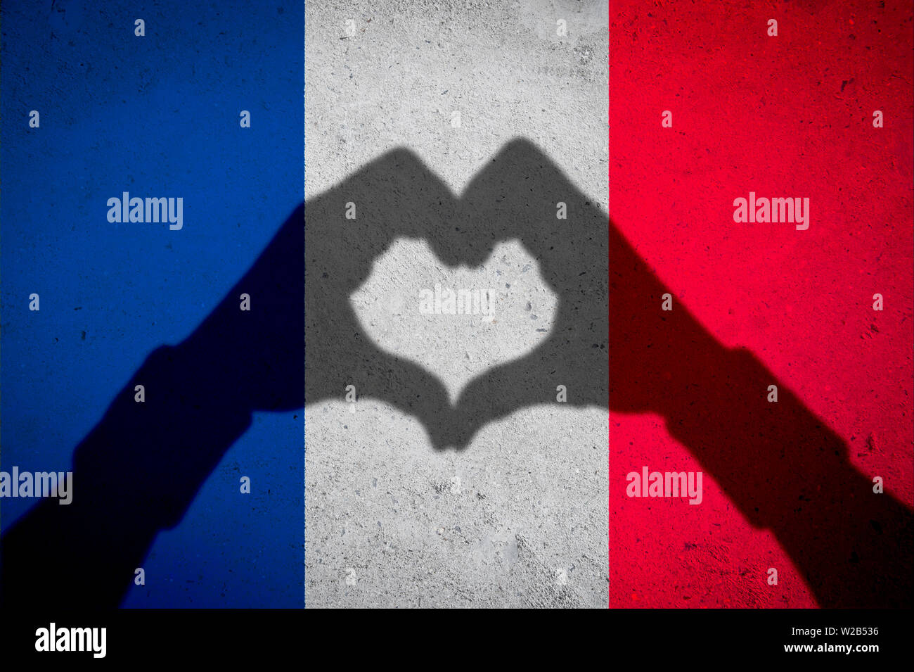 Hände und Herzen Form Schatten auf französische Flagge Hintergrund auf strukturierte grunge Betonwand Stockfoto