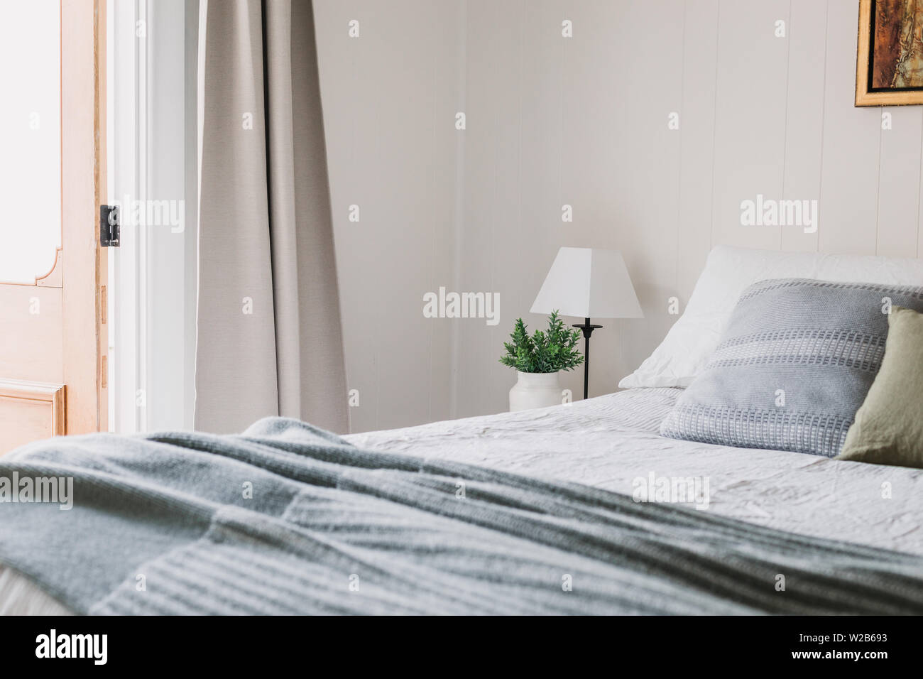 Land Schlafzimmer mit Nahaufnahme Bild von Bett und Blick auf Holz Tür Öffnung nach außen Stockfoto