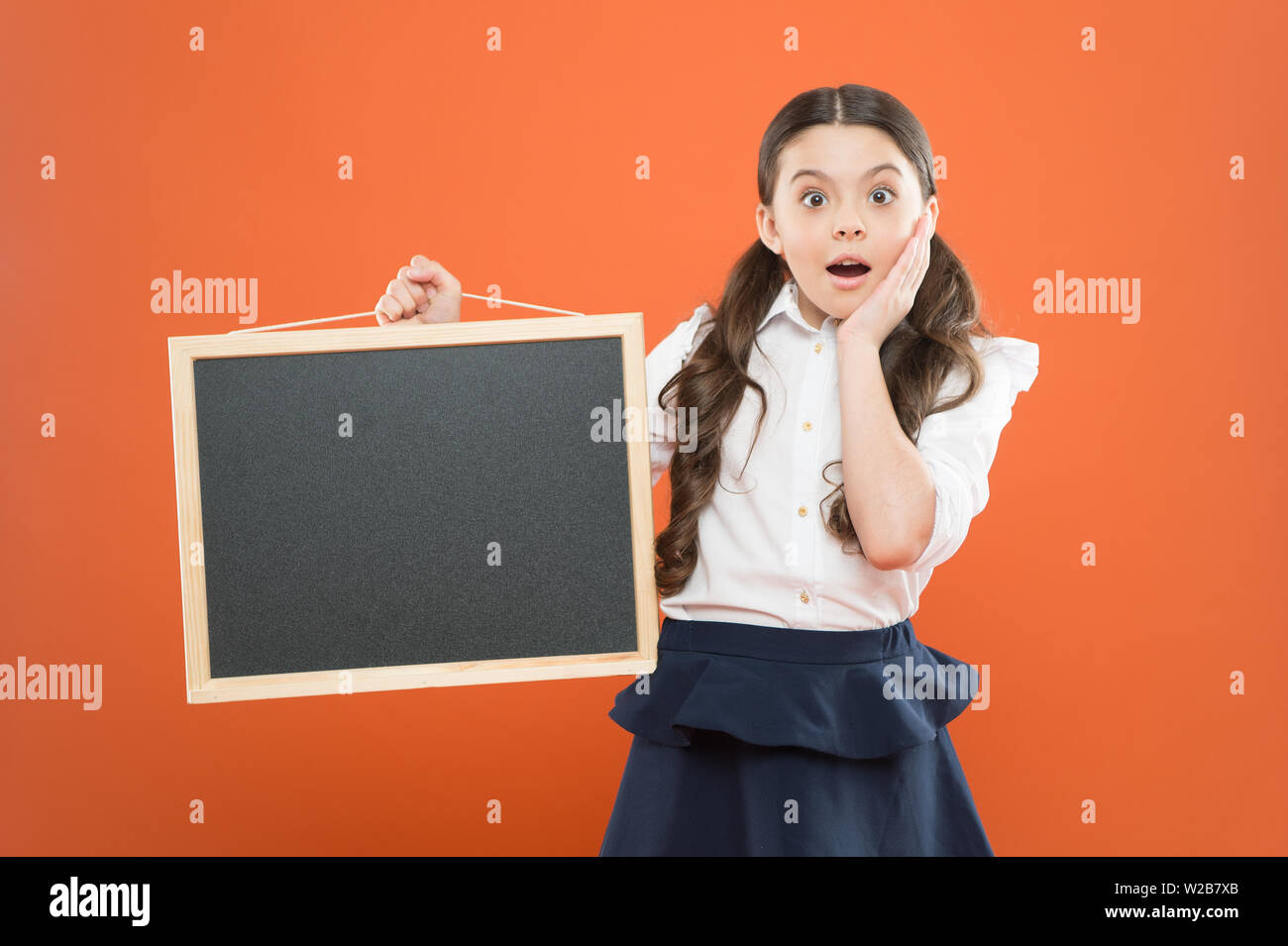 Oh mein Gott. Überrascht Schüler in Schuluniform. kopieren. Kommerzielle Vermarktung conept. Business School Anzeige. Neue shopping Idee. Schule Market Sales. Beschilderung. Überrascht schule mädchen mit blackboard. Stockfoto