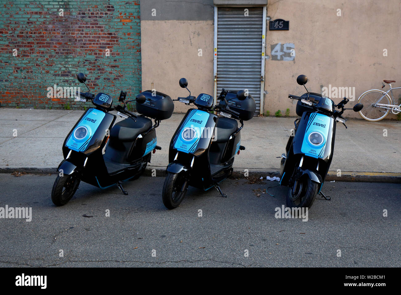 Revel dockless Vermietung elektrische Mopeds in einer Straße geparkt Stockfoto