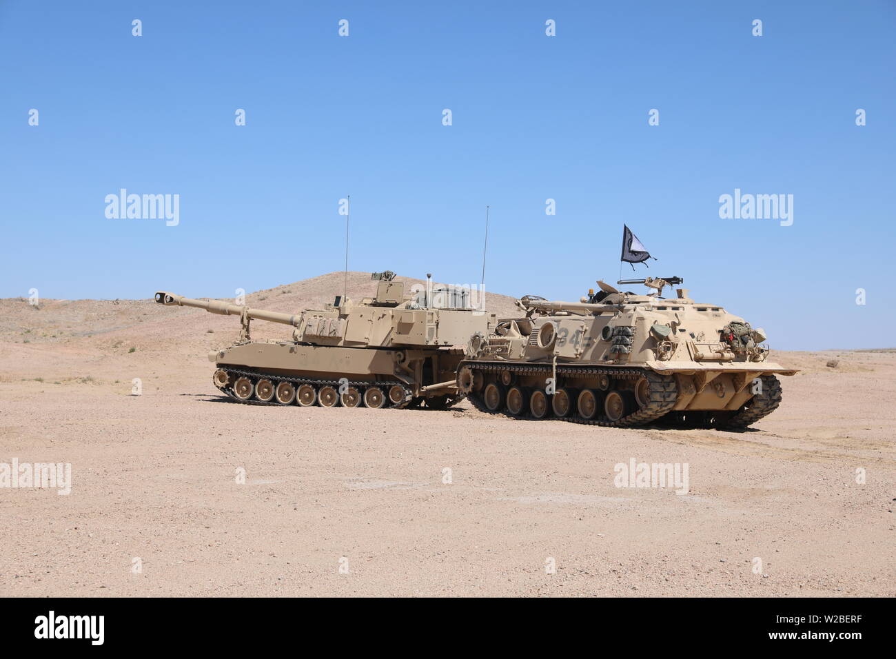 North Carolina National Guard M88 Recovery Vehicle schleppt ein M109A6 Paladin auf das erste Bataillon, 113 Field Artillery während des Betriebs Hickory Sting in Fort Irwin, Kalifornien, 4. Juli 2019 zugewiesen. Betrieb Hickory Sting ist ein entschlossenes Handeln Rotation auf kombinierte Waffen Manöver und kollektive schießwesen am National Training Center, Fort Irwin, Kalifornien fokussiert, um die Fähigkeiten des 30. gepanzerten Brigade Combat Team in der Schulungsumgebung zu validieren und eine Global entgegenkommende Brigade bereit zu implementieren, zu kämpfen und zu gewinnen. (Foto von Sgt. Wayne Becton, North Carolina National Guard Stockfoto