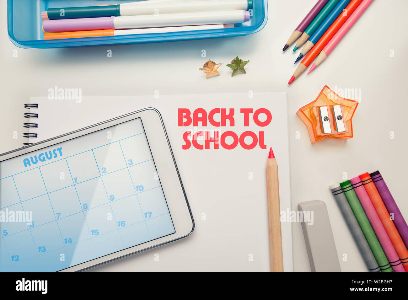 Zurück zu Schule liefert auf einem weißen Schreibtisch mit Tablet-PC oder Touchscreen, Wachsmalstifte, Buntstifte und Marker organisiert. Stockfoto