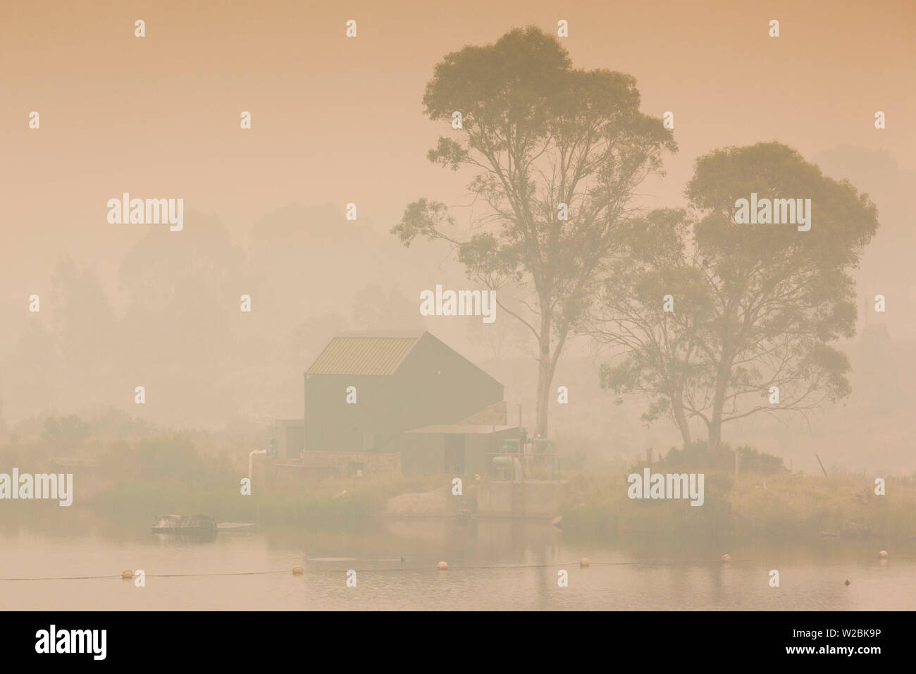 Australien, New South Wales, NSW, Kosciuszko National Park, Thredbo, See Reflexion mit Rauch von Waldbränden, Dämmerung Stockfoto