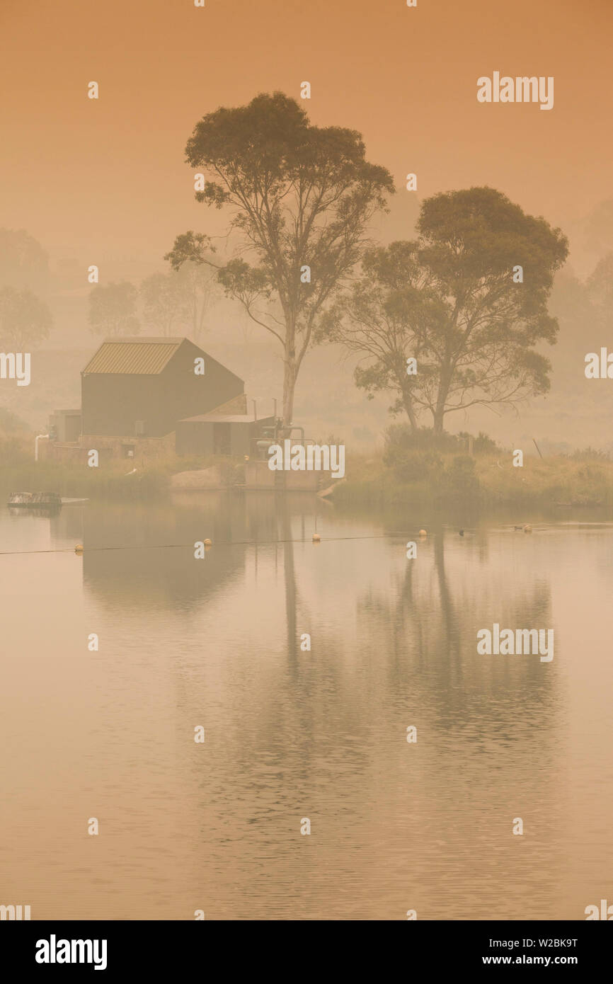 Australien, New South Wales, NSW, Kosciuszko National Park, Thredbo, See Reflexion mit Rauch von Waldbränden, Dämmerung Stockfoto