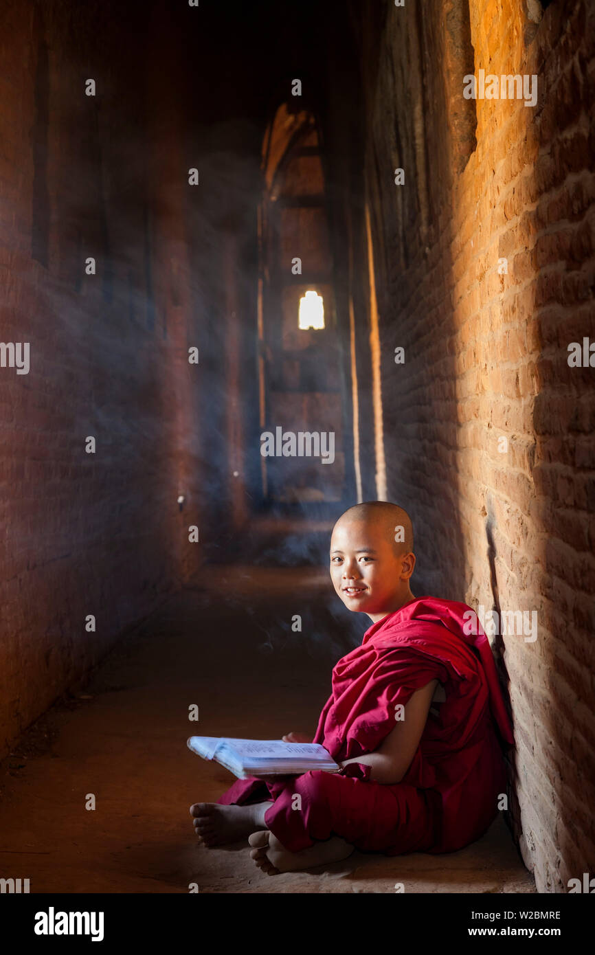 Junger Mönch in Pagode, Bagan (Pagan), Myanmar (Burma) lesen Stockfoto