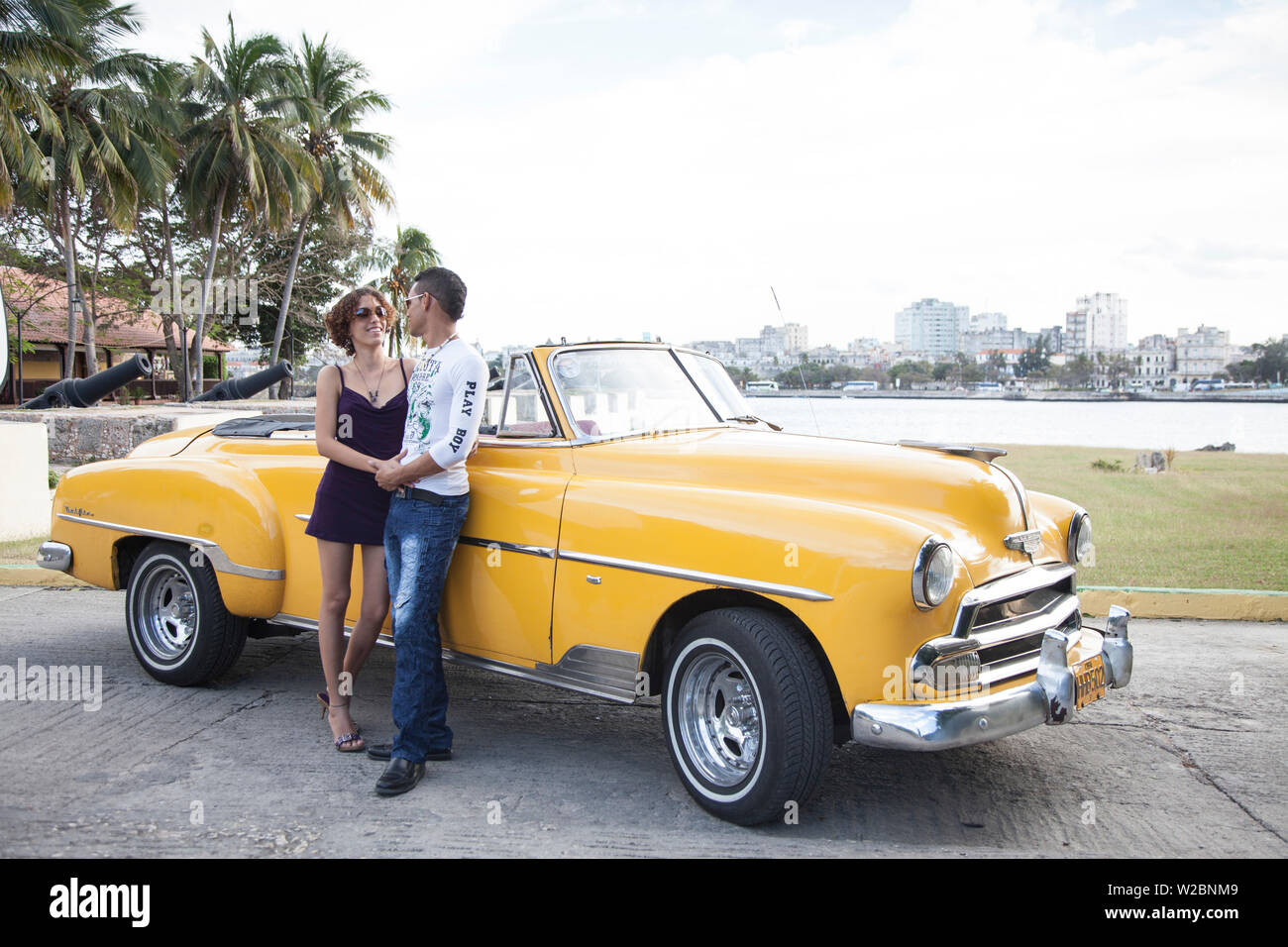 Paar posiert mit einem klassischen 50 Chevrolet, Havanna, Kuba (MR) Stockfoto