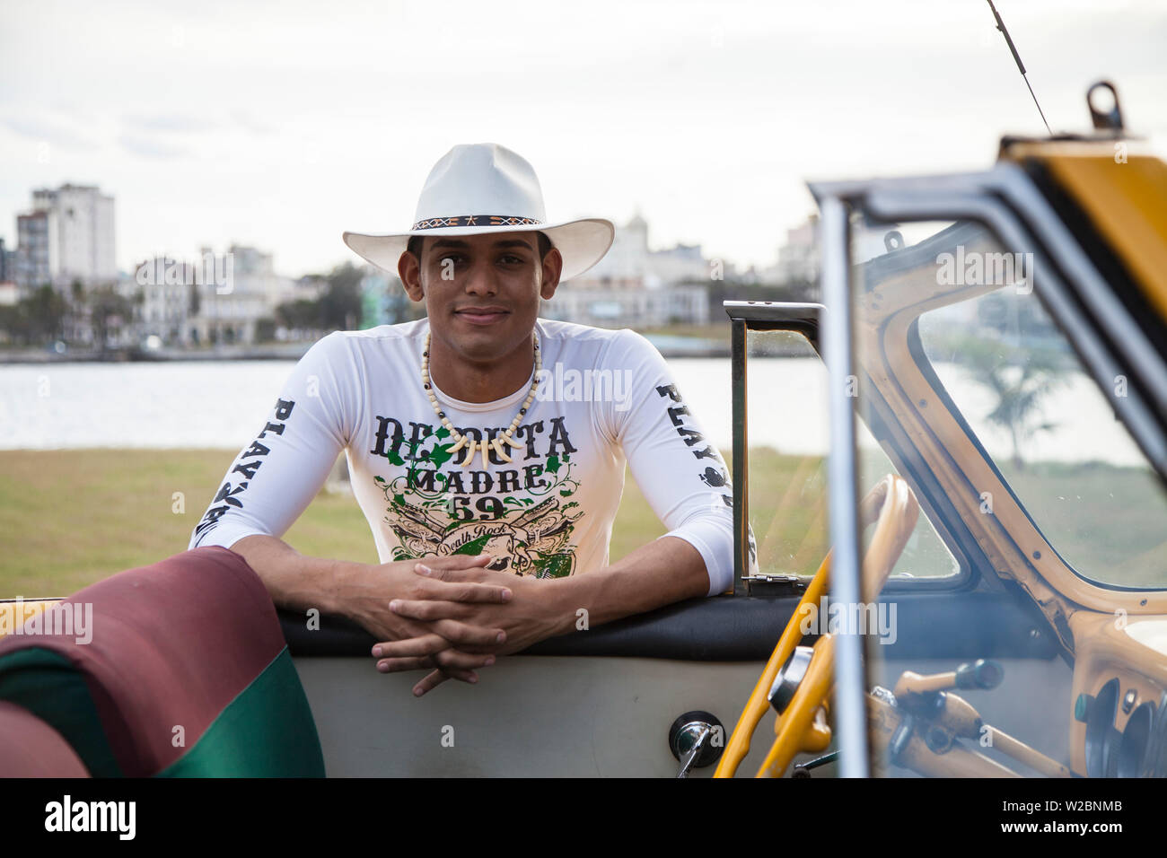Junger Mann posiert mit einem klassischen 50 Chevrolet, Havanna, Kuba (MR) Stockfoto