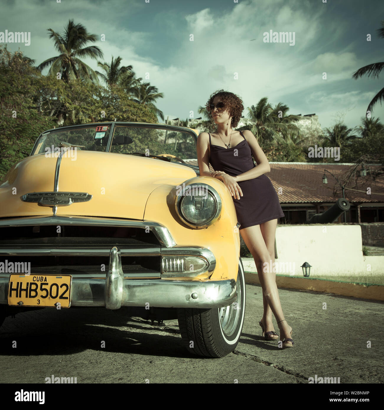 Junge Frau posiert mit einem klassischen 50 Chevrolet, Havanna, Kuba (MR) Stockfoto