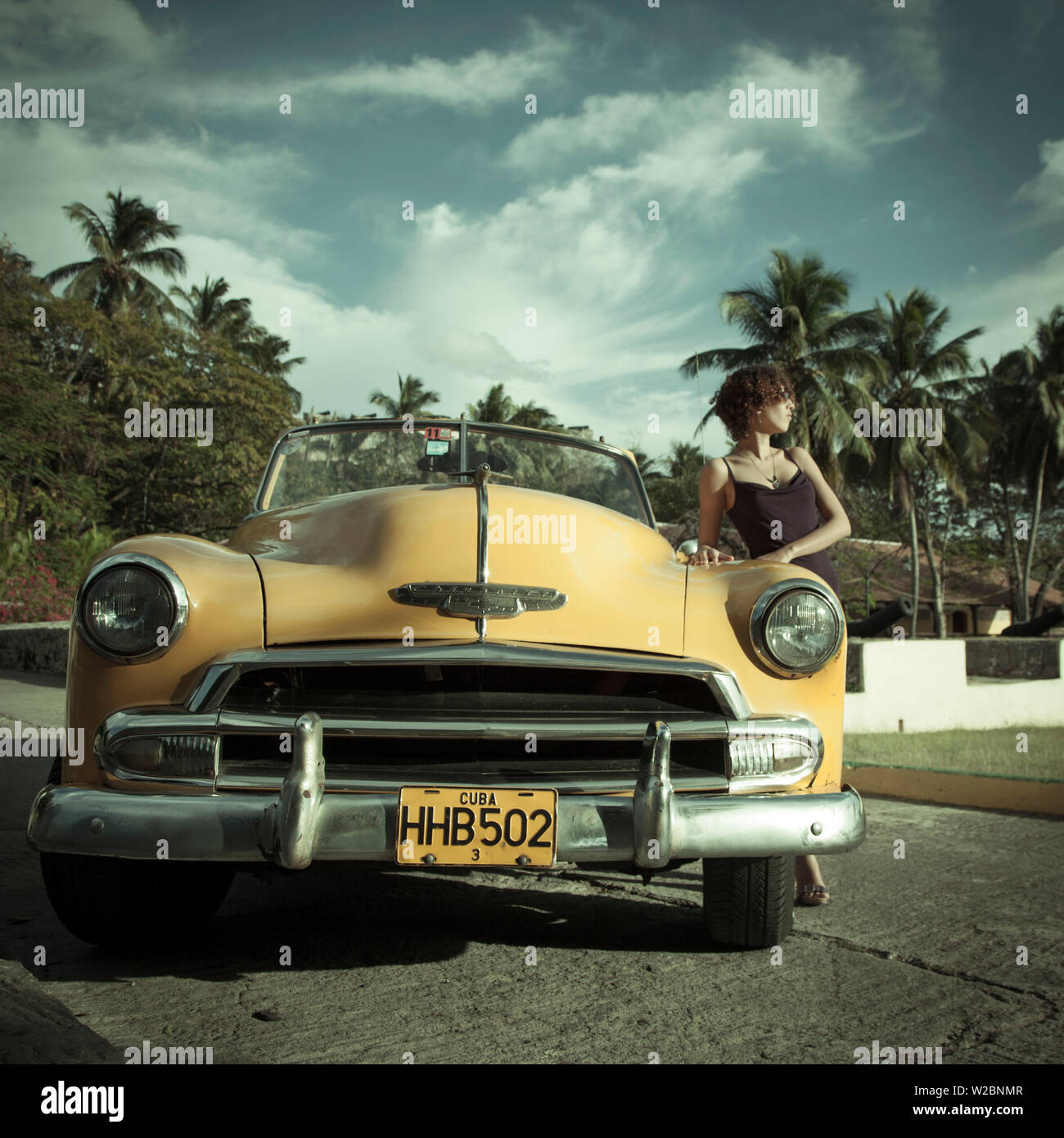 Junge Frau posiert mit einem klassischen 50 Chevrolet, Havanna, Kuba (MR) Stockfoto