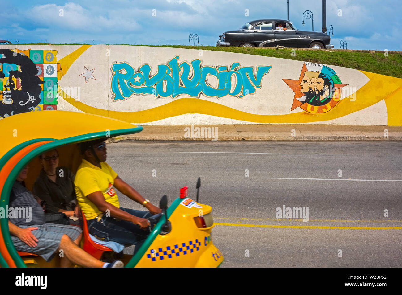 Kuba, Havanna, Revolucion Wandgemälde und gelbe Coco Taxi Stockfoto