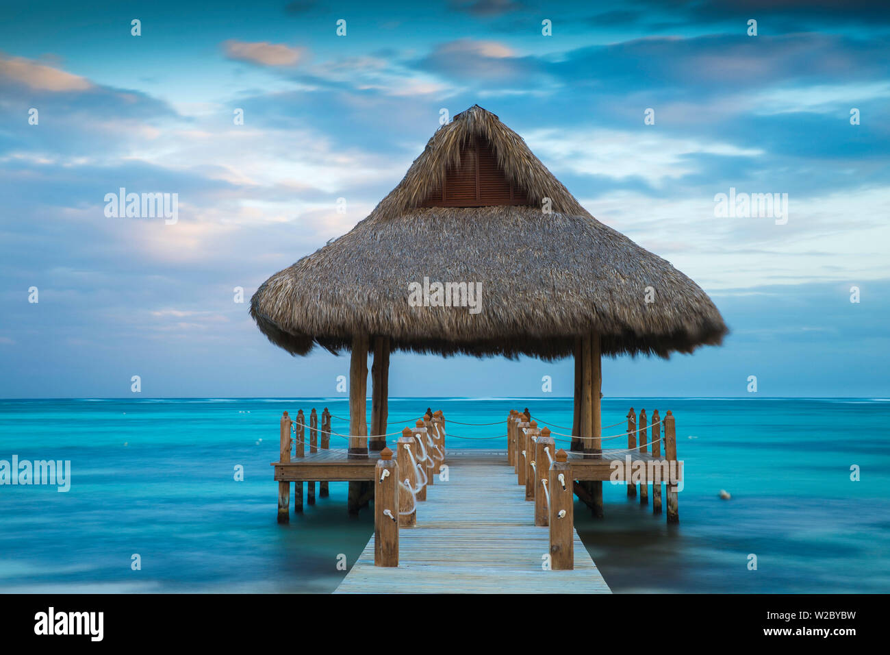 Dominikanische Republik, Punta Cana, Playa Blanca, Hölzerne Seebrücke mit strohgedeckten Hütte Stockfoto