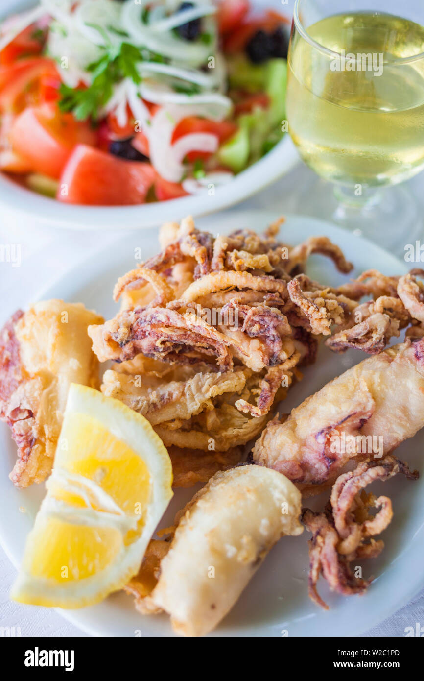 Griechenland, Ostmakedonien und Thrakien, Kavala, Griechischer Salat mit gebratenen Tintenfisch und Glas Wein Stockfoto