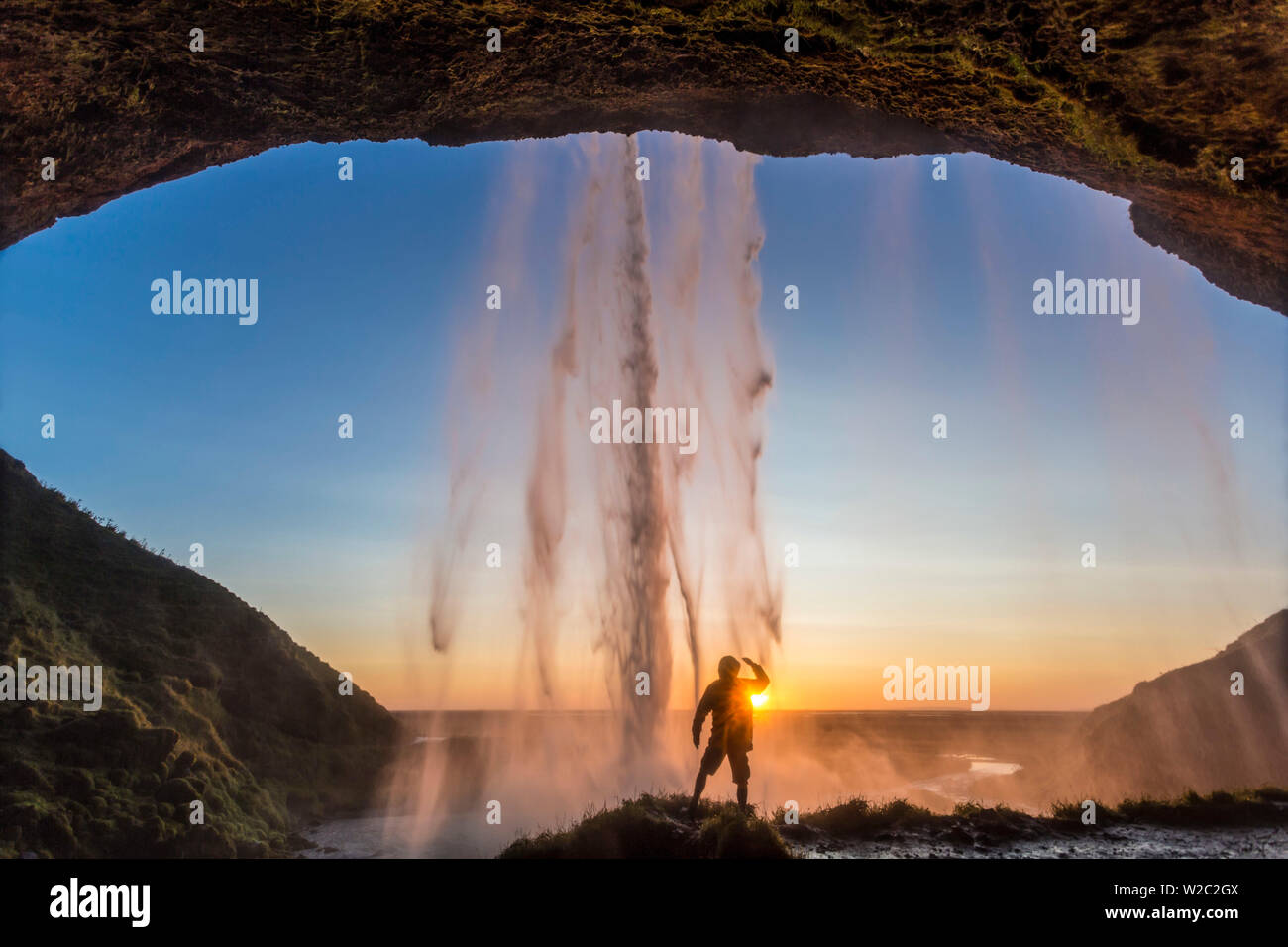 Mann hinter der Wasserfall Seljalandsfoss, Suourland (South Iceland), Island Stockfoto