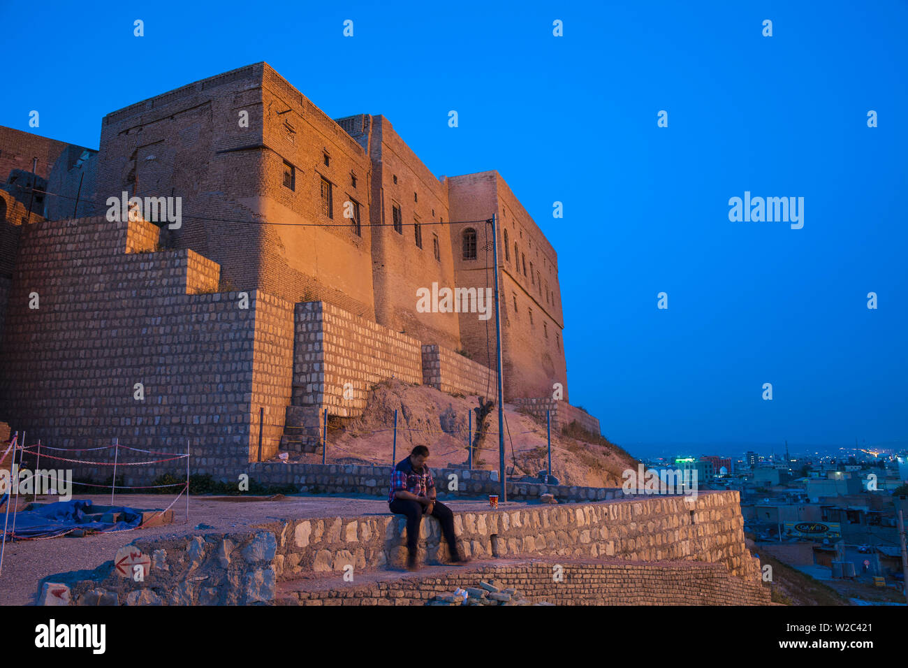 Irak, Kurdistan, Erbil, Mann an der Wall in der Zitadelle sitzen - behauptete die älteste durchgehend bewohnte Stadt der Welt. Stockfoto