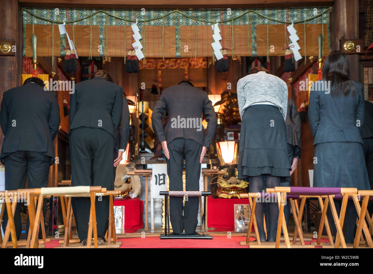 Unternehmer & Frauen besuchen Shinto Tempel vor der Arbeit Tokio, Japan Stockfoto