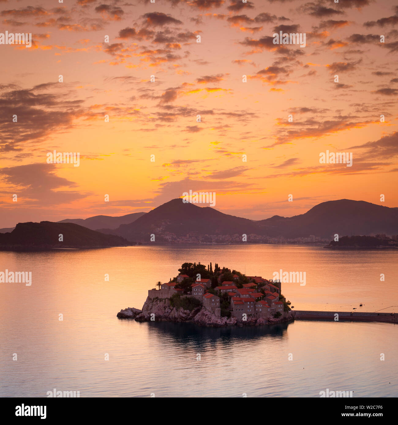 Die malerische Insel Dorf Sveti Stephan beleuchtet bei Sonnenuntergang, Sveti Stefan, Montenegro Stockfoto