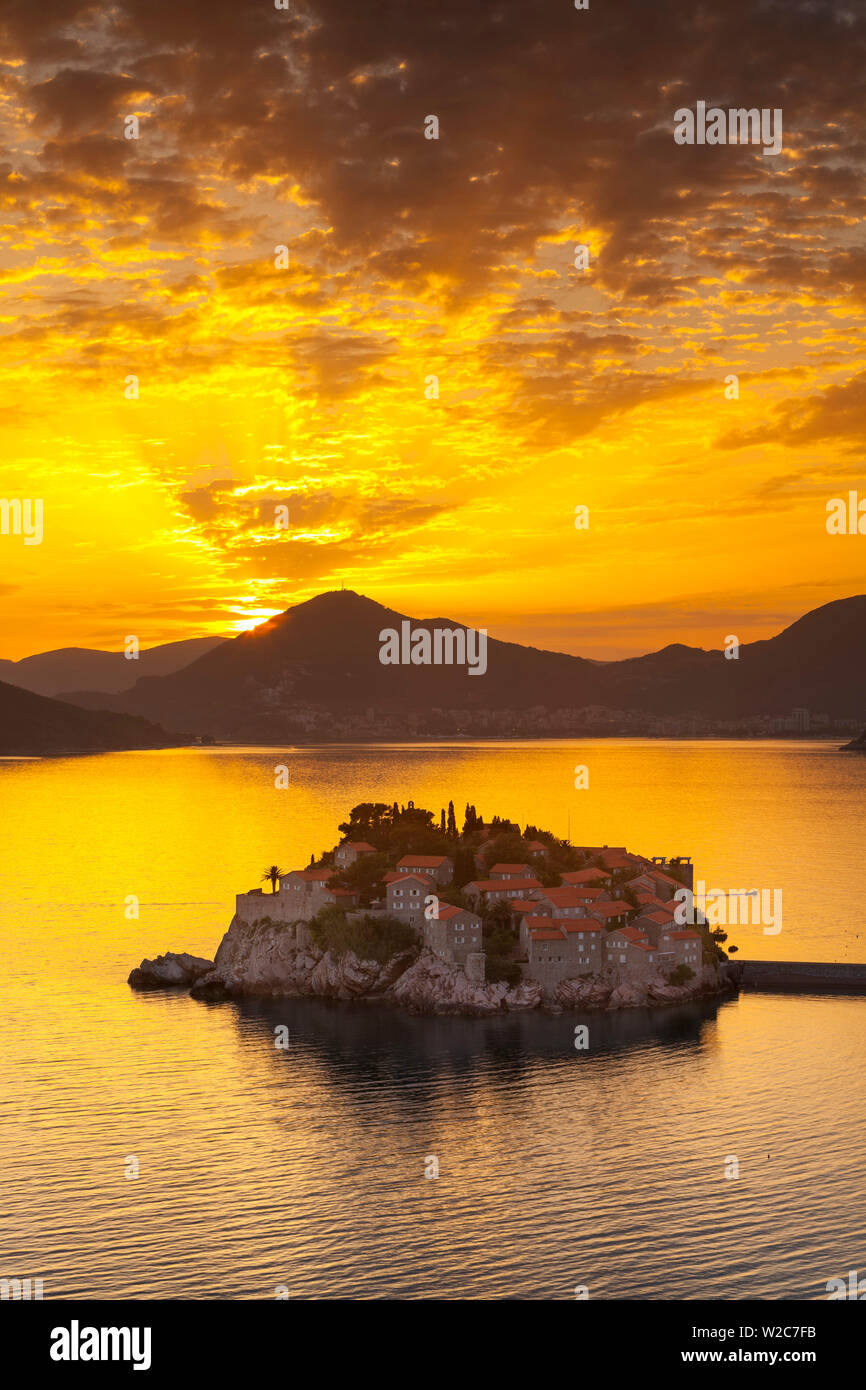 Die malerische Insel Dorf Sveti Stephan beleuchtet bei Sonnenuntergang, Sveti Stefan, Montenegro Stockfoto