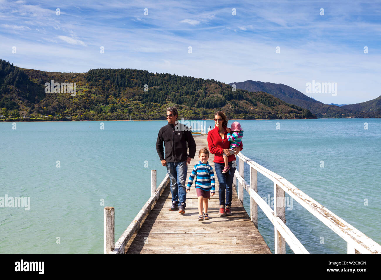 Familie zu Fuß auf malerischen Wharf in der idyllischen Kenepuru Sound, Marlborough Sounds, Südinsel, Neuseeland Stockfoto