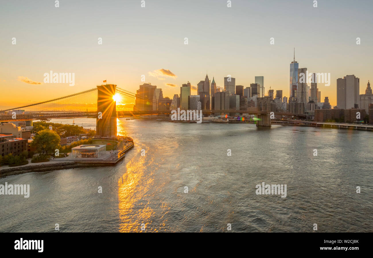 USA, New York, Skyline von Lower Manhattan und Brooklyn Bridge über den East River bei Sonnenuntergang Stockfoto