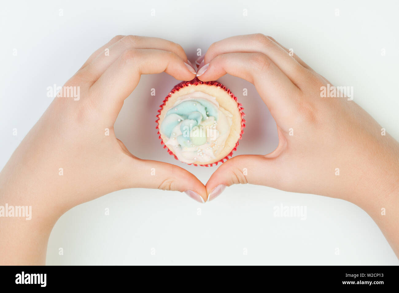 Schöne gepflegte Nägel Frau mit Kuchen. Hände in Form Herz Stockfoto