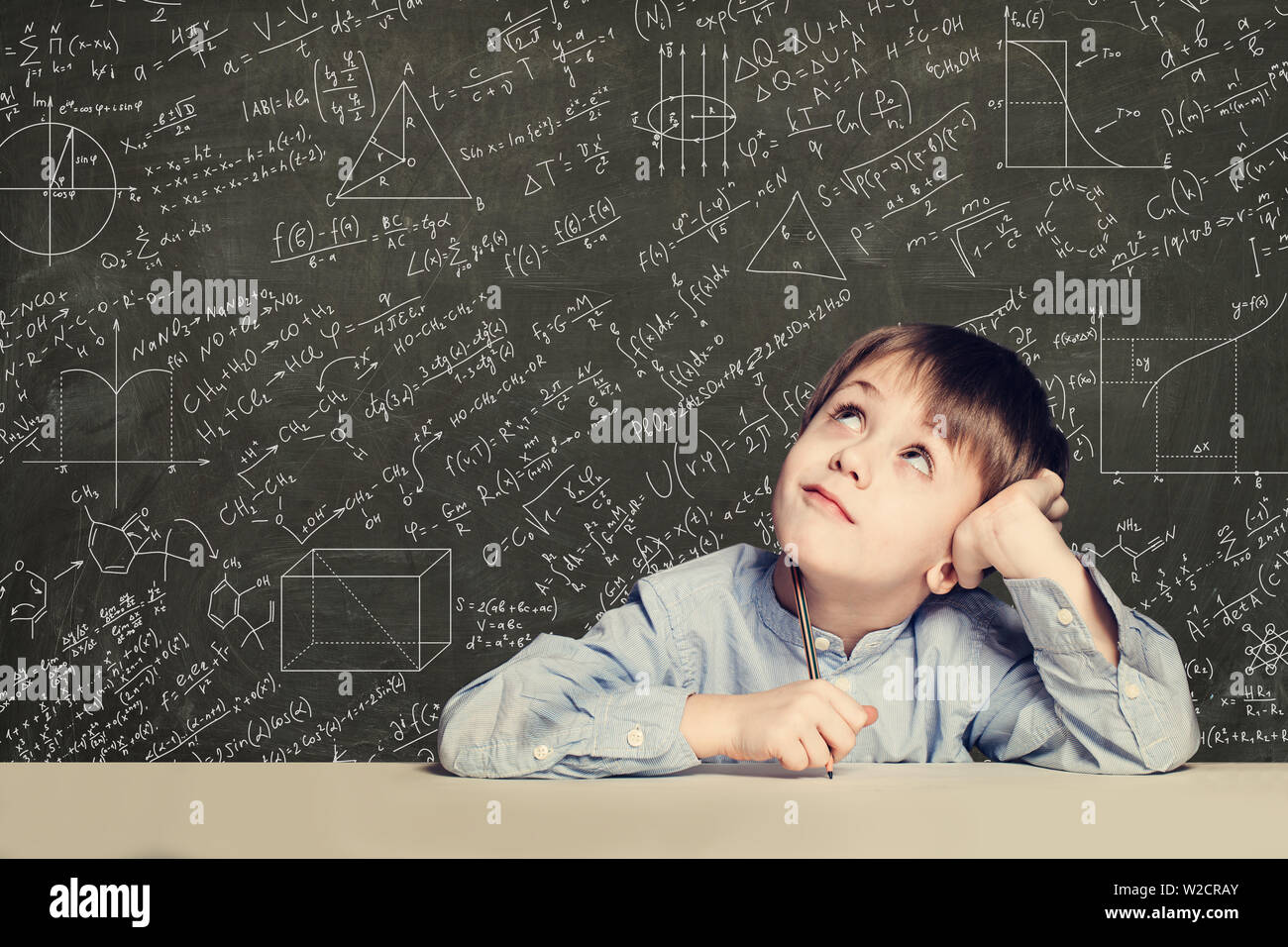 Smart kind Student auf blackboard Hintergrund mit Wissenschaft Formeln niedlich. Lernen Wissenschaft Konzept. Stockfoto