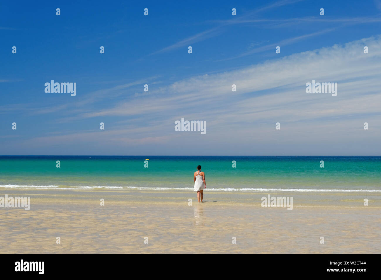 Eine Frau, die zu Fuß ins Meer auf godrevy Beach, Cornwall Stockfoto