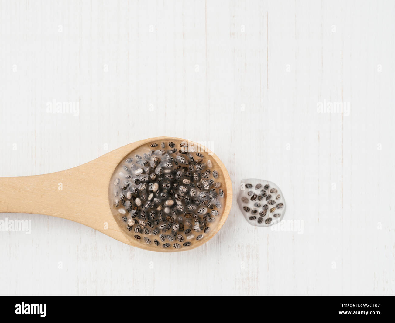 Wet Samen oder Chia Chia-Ei in hölzernen Löffel auf weißem Holz- Hintergrund. Eiersatzprodukte, Eiern, veganern austauschen Eier Konzept Raum für Text kopieren. Stockfoto