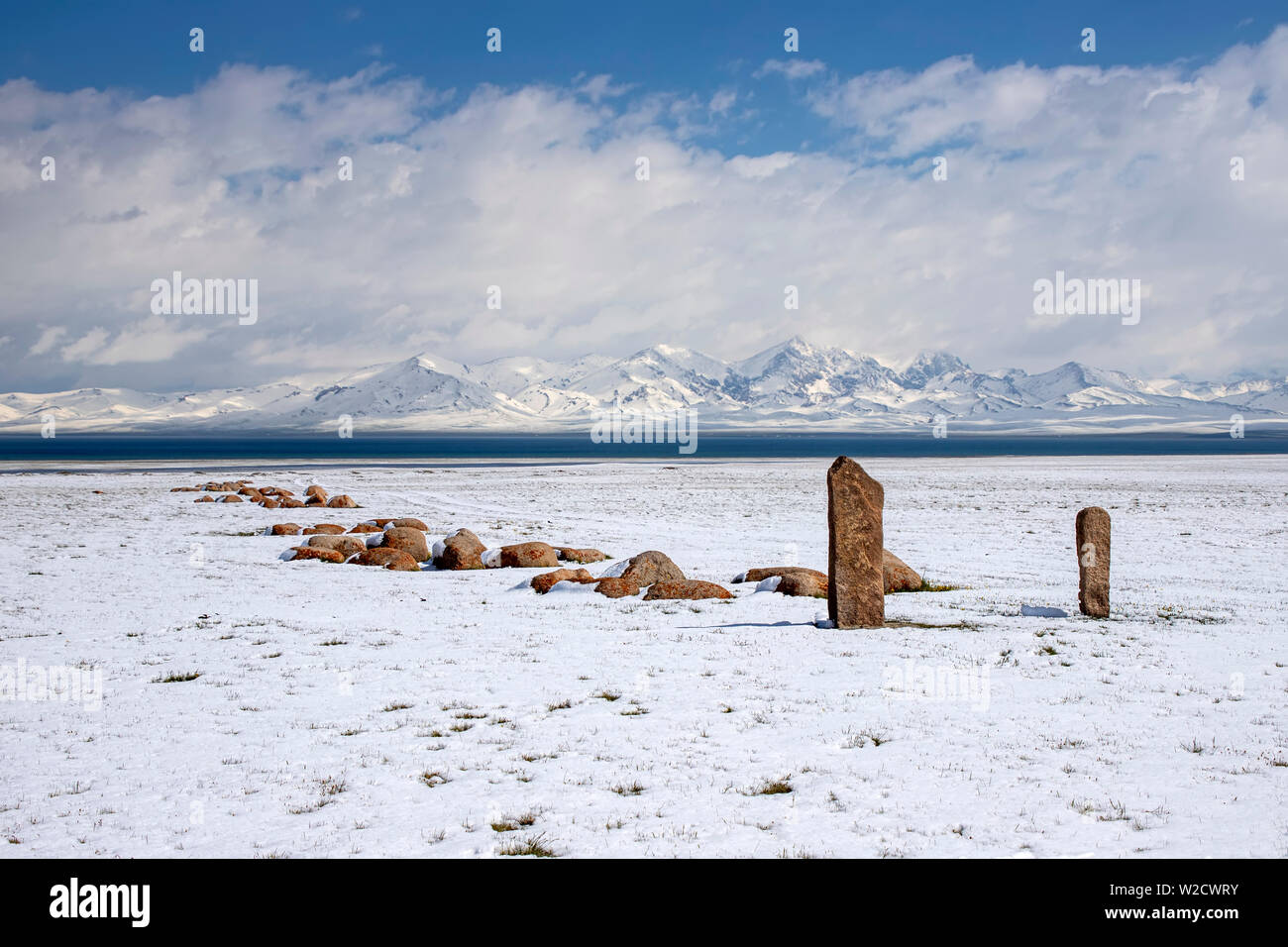 Traditionelle unvergessliche Steine am Ufer des Son-Kul See vor dem Hintergrund der schneebedeckten Berge. Das Reisen in Kirgistan. Stockfoto