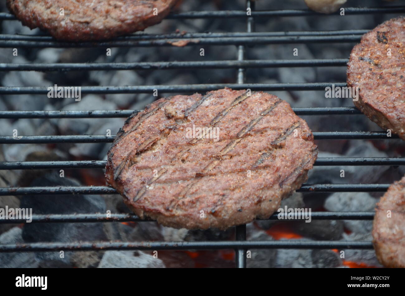 Würstchen und Rindfleisch Burger Kochen auf dem Grill Stockfoto