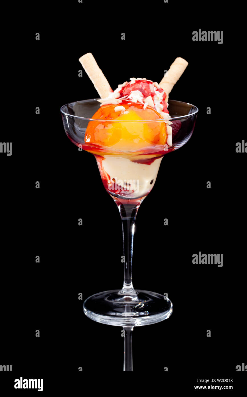 Eisbecher: eine Tasse Pfirsicheiscreme auf schwarzem Hintergrund Stockfoto