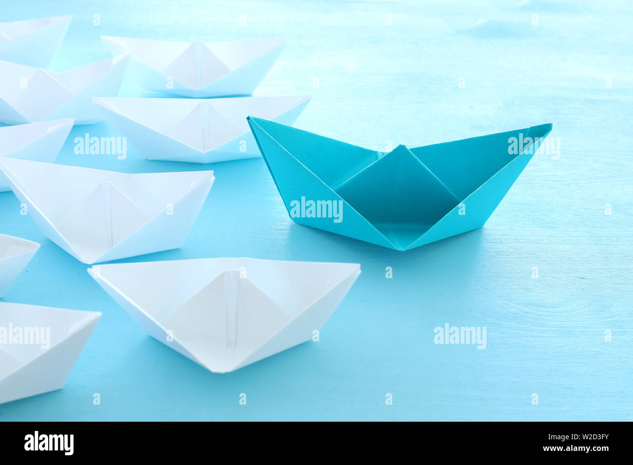 Business. Führung Konzept Bild mit Papier Boote auf Blau Holz- Hintergrund. Ein Führer führen. Stockfoto