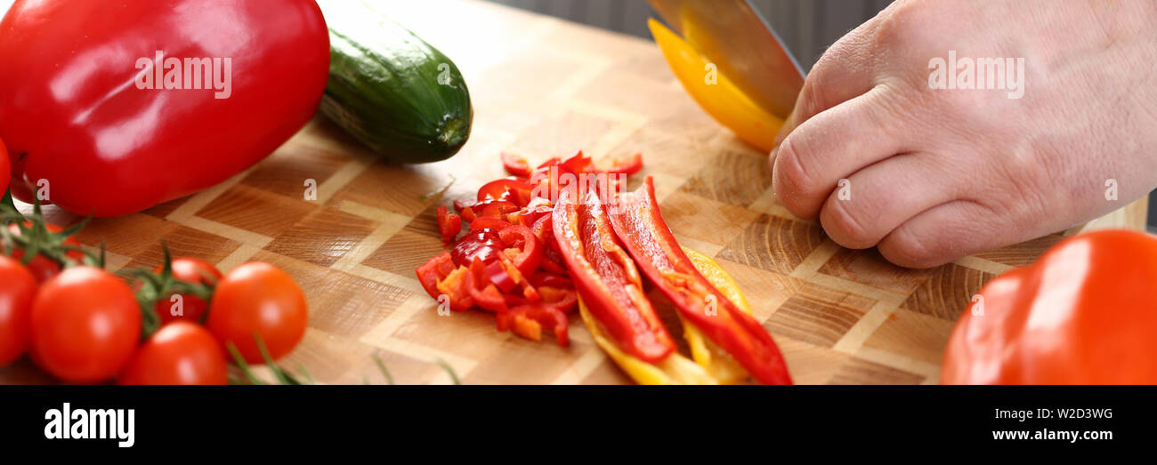 Männliche Hände Schneiden gelbe Paprika Salat Zutat Stockfoto