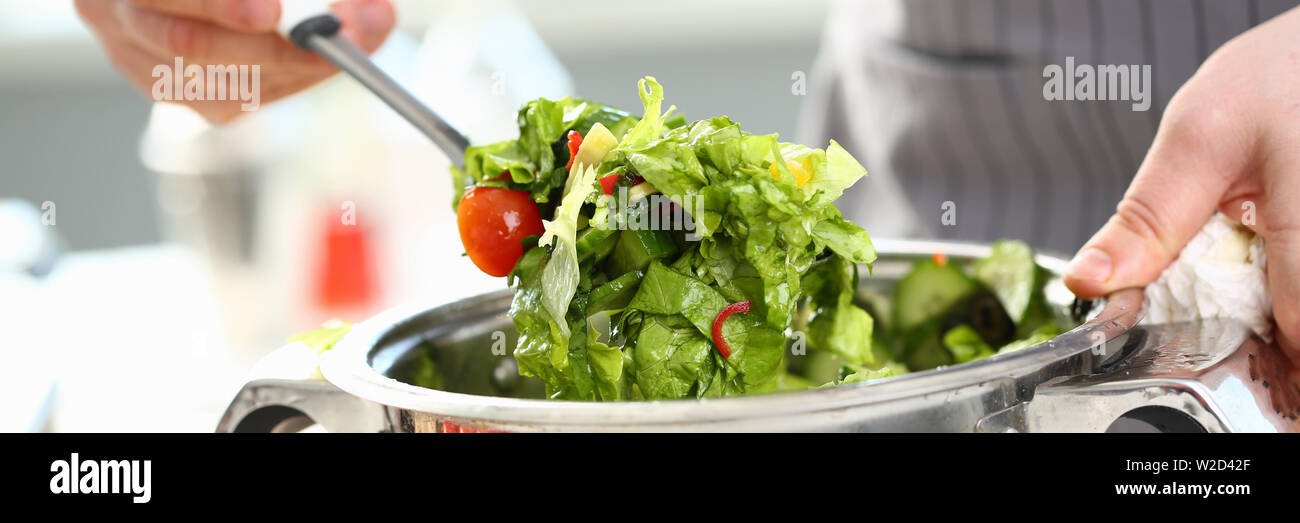 Männliche Hände mischen Organische gehackt Salat Stockfoto