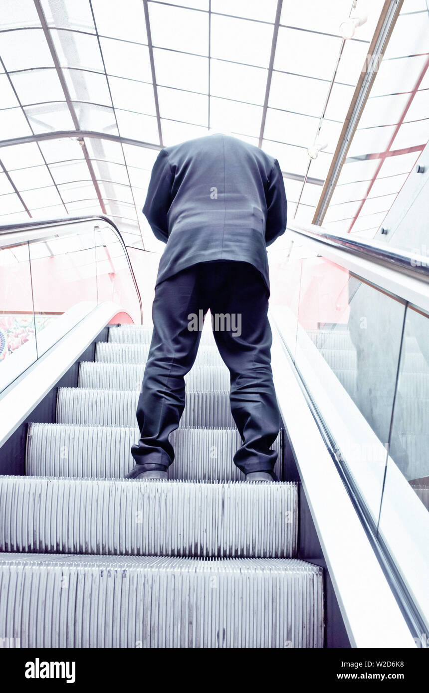 Mann in Anzug, mit einer Rolltreppe Stockfoto