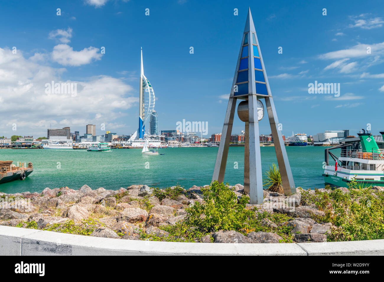 Der Tide Clock, gestaltet von Paul am Besten auf der Uferpromenade am Gosport, Hampshire, mit Blick auf den Hafen und das Wahrzeichen von Portsmouth Spinnaker Tower. Stockfoto