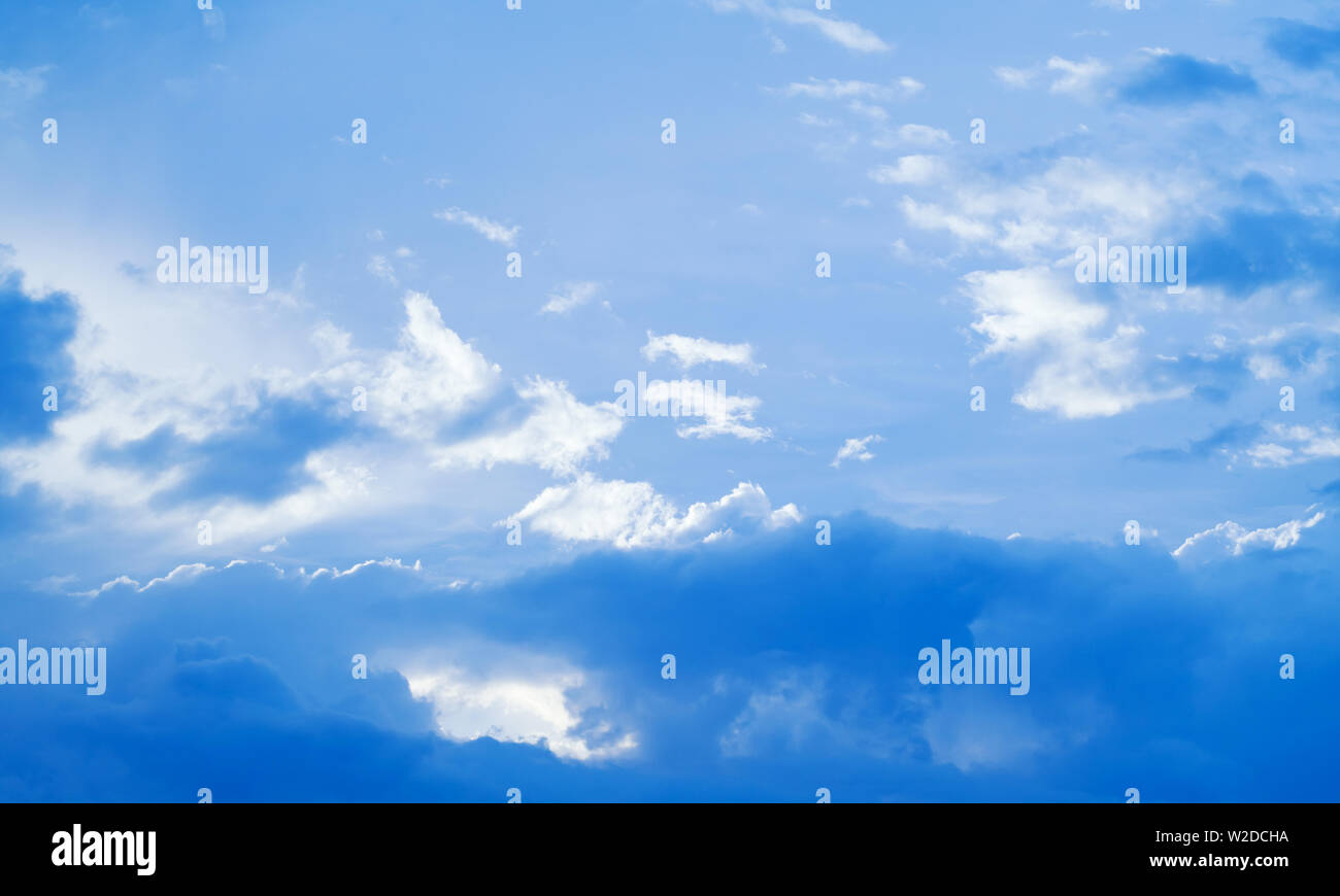 Blauer Himmel mit Cumulus und Zirruswolken bei Tag. Natürliche Hintergrund Foto Textur Stockfoto