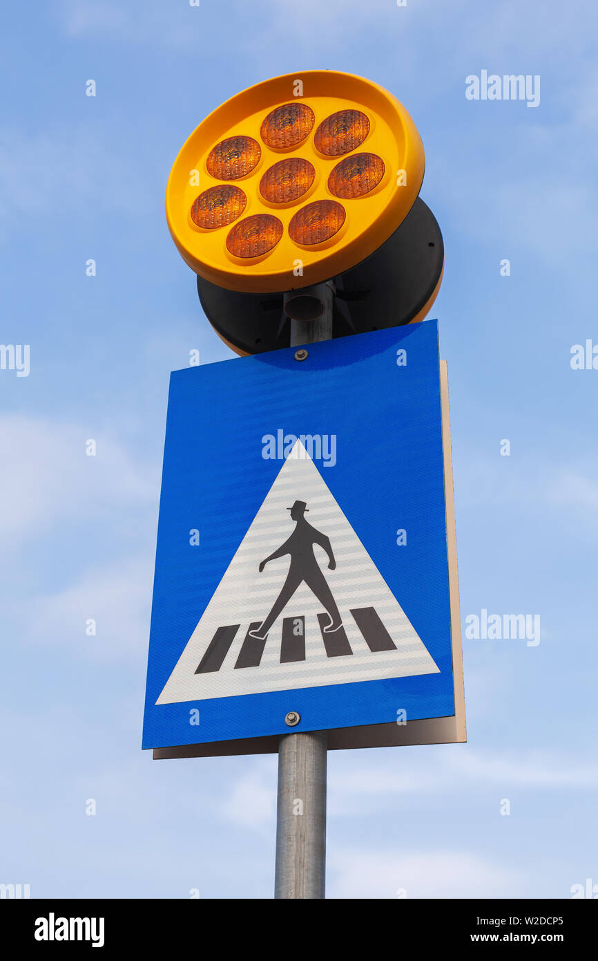 Fußgängerampel. Schild mit nachschauen gehen Mensch und gelbe Warnleuchten über blauen Himmel Hintergrund Stockfoto