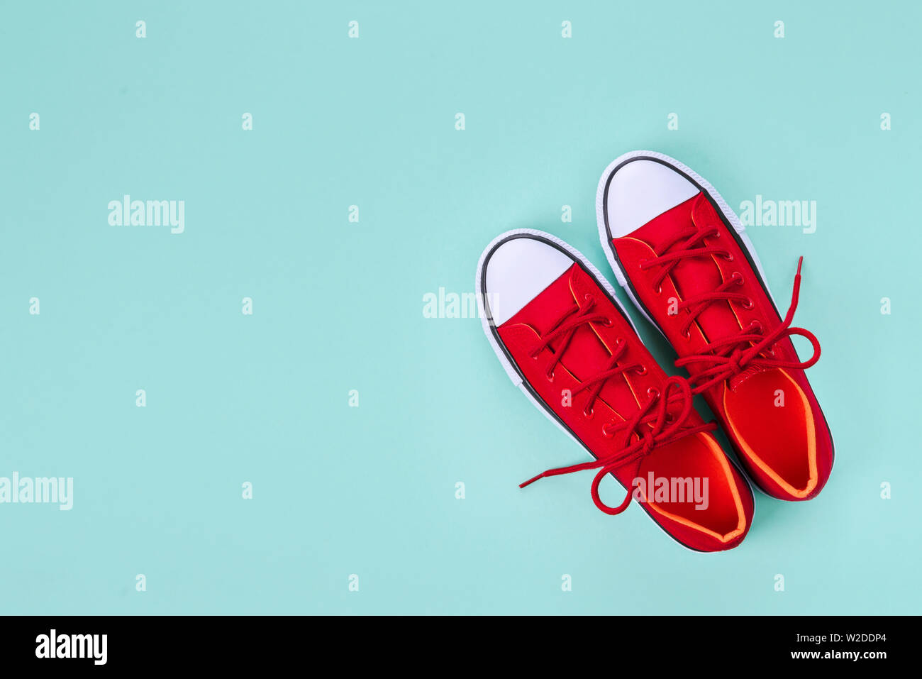 Neue rote Turnschuhe auf grünem Hintergrund mit Kopie Raum. Stockfoto