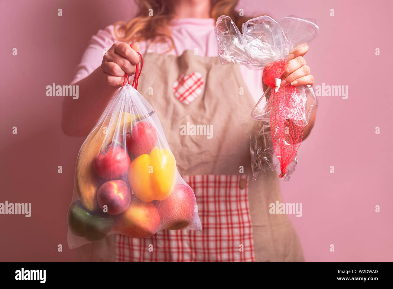 Verringerung der Abfälle Konzept mit einer Frau mit einem wiederverwendbaren Umweltfreundliche Tasche mit Gemüse und leeren Kunststoff Lebensmittel Wrapper. Keine Kunststoff-Wrapper. Stockfoto