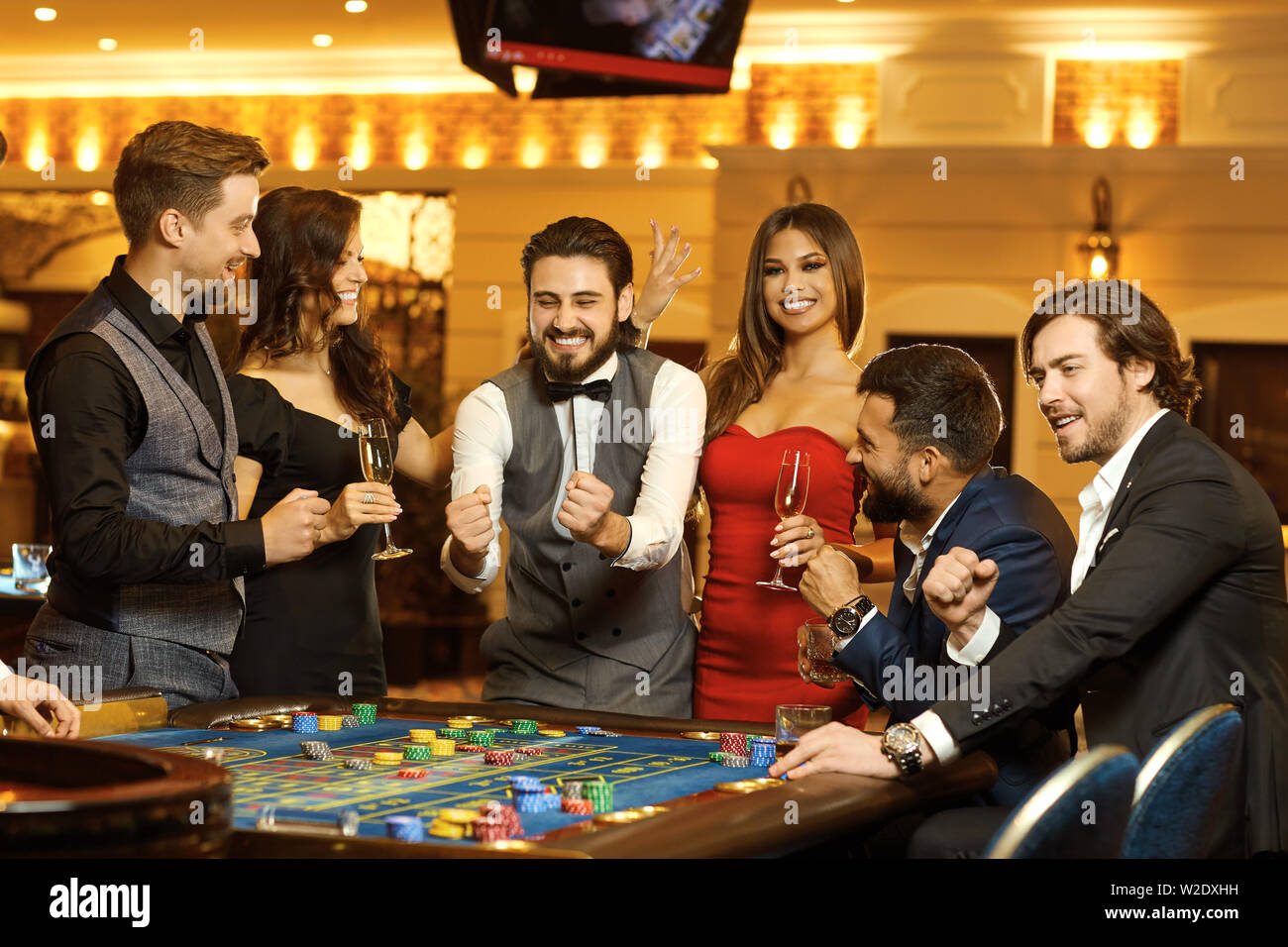 Gruppe glückliche Menschen Wetten gambiling an den Roulette Tisch im Casino. Das Spielen in einem Casino. Stockfoto